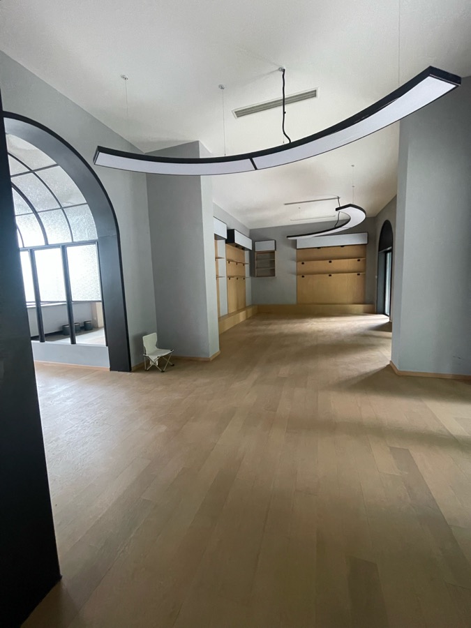 品牌展览厅现场，显示现有高挑空间和固定墙体
